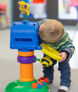 Robert bends over to look inside a toy letterbox