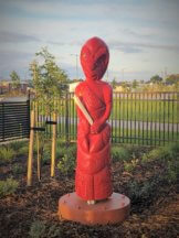 Figure 1 - Carved statue of the local ancestor Tamaoho, painted red and holding a scroll to symbolize wisdom