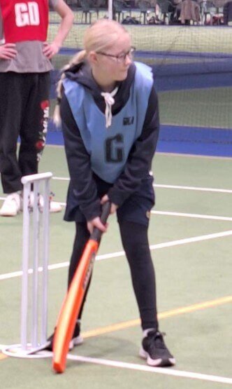 Figure 1 - Ākonga standing with a cricket bat ready for the ball to come with cricket stumps behind her