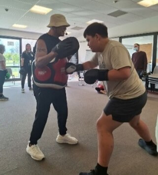 Figure 2 - Transition staff member and ākonga standing with boxing gloves on doing Boxfit